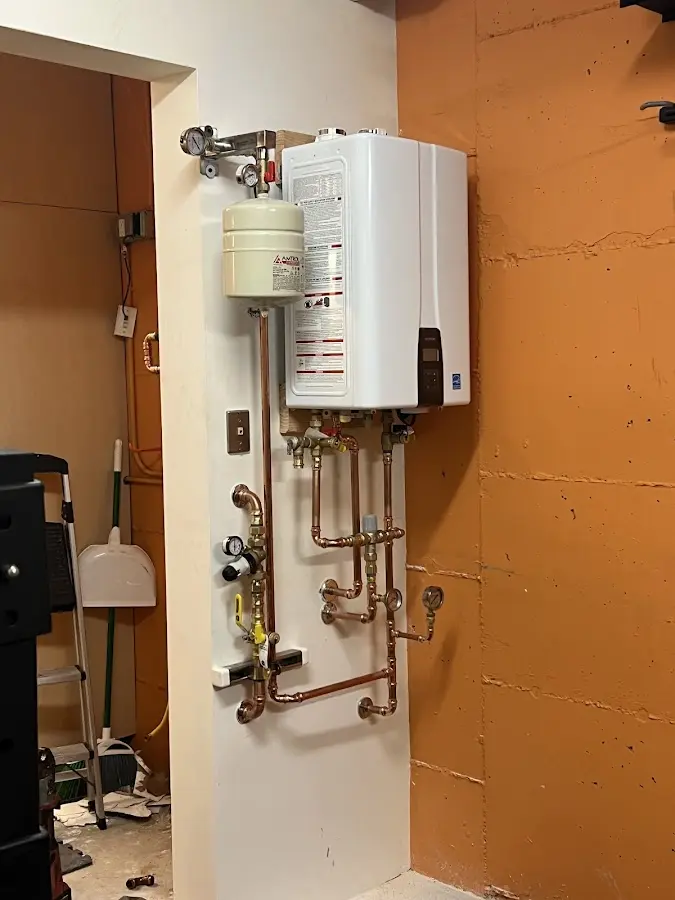 Plumbing technician inspecting water heater connections in Peekskill